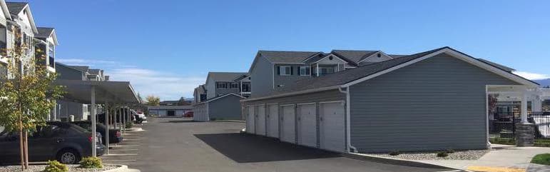 Row of matching carriage-style garage and storage doors installed across an apartment community in Spokane